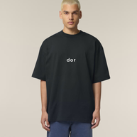 Person wearing a black t-shirt with 'dor' logo on a beige background