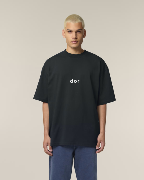 Person wearing a black t-shirt with 'dor' logo on a beige background
