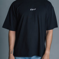 Person wearing a black t-shirt with 'zbor' logo against a gray background