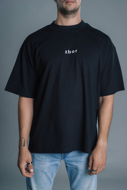Person wearing a black t-shirt with 'zbor' logo against a gray background