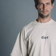 Man wearing a Natural RAW t-shirt with 'dor' logo against a gray background