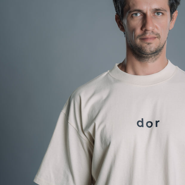 Man wearing a Natural RAW t-shirt with 'dor' logo against a gray background