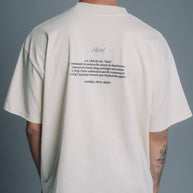 Person wearing a Natural RAW t-shirt with text on the back against a gray background